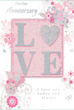 In this image, a romantic anniversary card lies open to view, its design echoing the softness and intimacy of a thoughtful gift chosen near Elephant and Castle. At the heart of the card's front, the word LOVE stretches across in raised, glittering letters, each one coated in a velvety, light-catching sparkle. Instead of a traditional O, a shimmering silver heart is set into the word, its slightly embossed surface giving the focal point a jewel-like finish. This motif rests on a gently glowing blush-pink panel that lifts away from the paler background, adding subtle dimension. Encircling the central word, delicate floral illustrations spill outward in pastel tones of blush, mauve, and soft ivory. Their petals are painted with a watercolor softness, and fine line work in pale grey traces stems and veins, much like the careful touch of a florist arranging stems on a workbench off New Kent Road. The flowers are accompanied by curling vines and tiny, whimsical flourishes-petals, swirls, and barely-there butterflies-that create a feeling of movement and grace, reminiscent of a spring garden stirred by a light breeze. Occasional touches of silvery detail highlight edges of petals and leaves, lending an understated elegance without distracting from the pastel harmony. Above and below the artwork, messages in flowing script read On Our Anniversary and I love you today and always, the lettering slender and poised, as if written slowly and with feeling. The overall look conveys quiet celebration and lasting affection, like a keepsake card that might be tucked beside a vase of fresh anniversary flowers in a home overlooking the bustle of Elephant and Castle, yet holding a world of private warmth within.